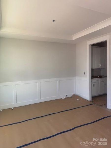 Dining room with tray ceiling and wainscoting