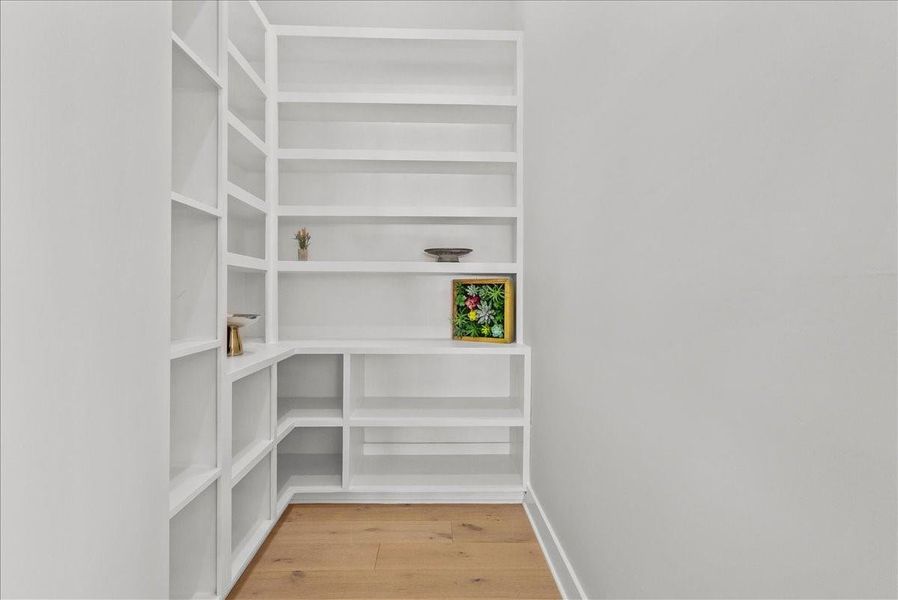 This photo showcases a minimalist corner with built-in white shelves, perfect for displaying decor. The light wood flooring adds warmth to the space. This photo showcases a minimalist corner with built-in white shelves, perfect for displaying decor. The light wood flooring adds warmth to the space.