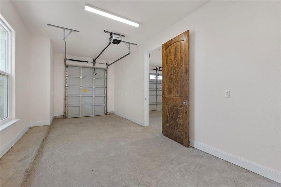 Garage with a garage door opener and baseboards
