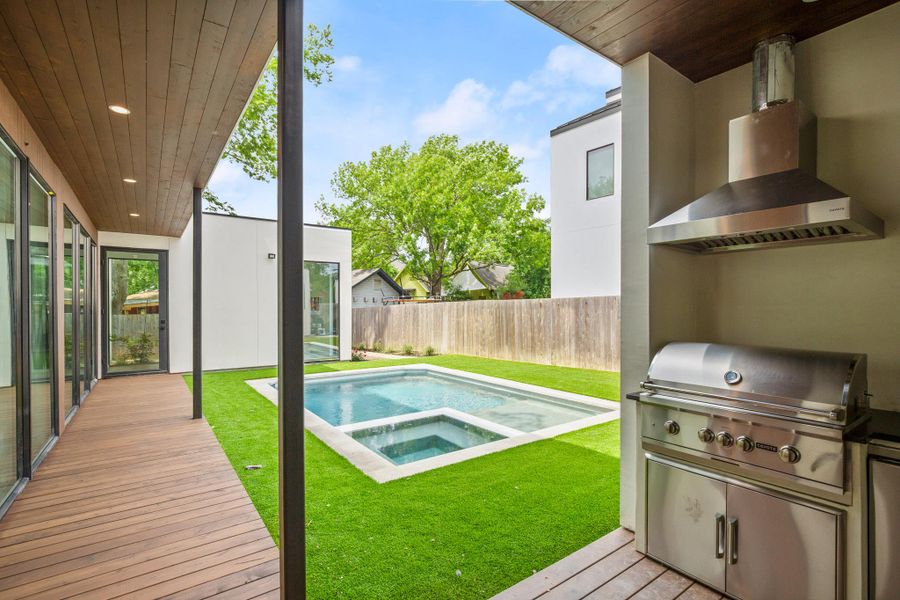 Relaxing pool / spa featuring a patio, a fenced backyard, grilling area, and a wooden deck