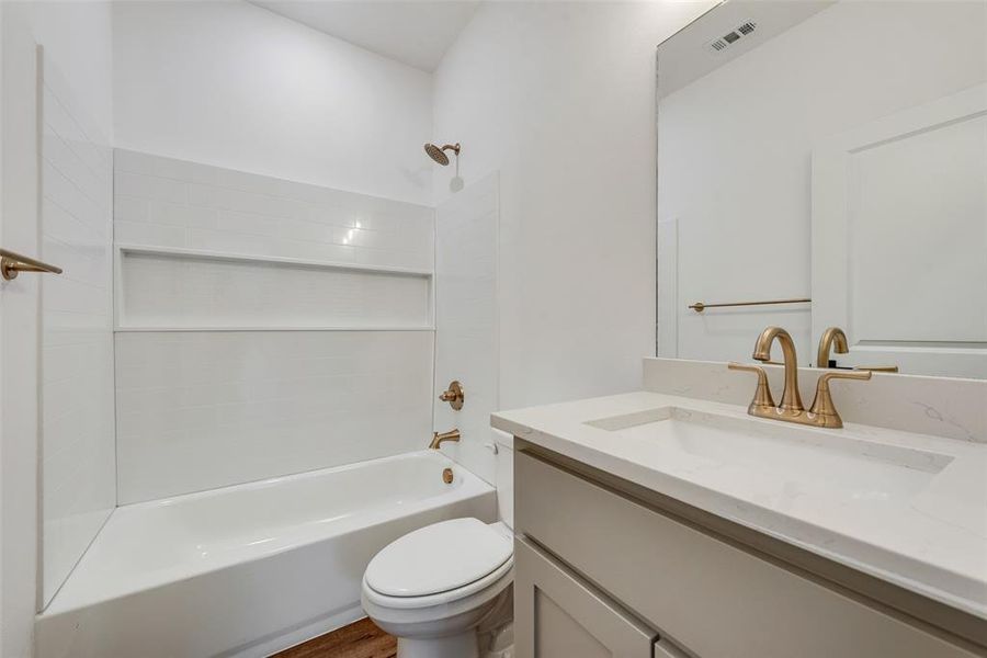 Bathroom with shower / bathtub combination, vanity, and wood finished floors Bathroom with shower / bathtub combination, vanity, and wood finished floors
