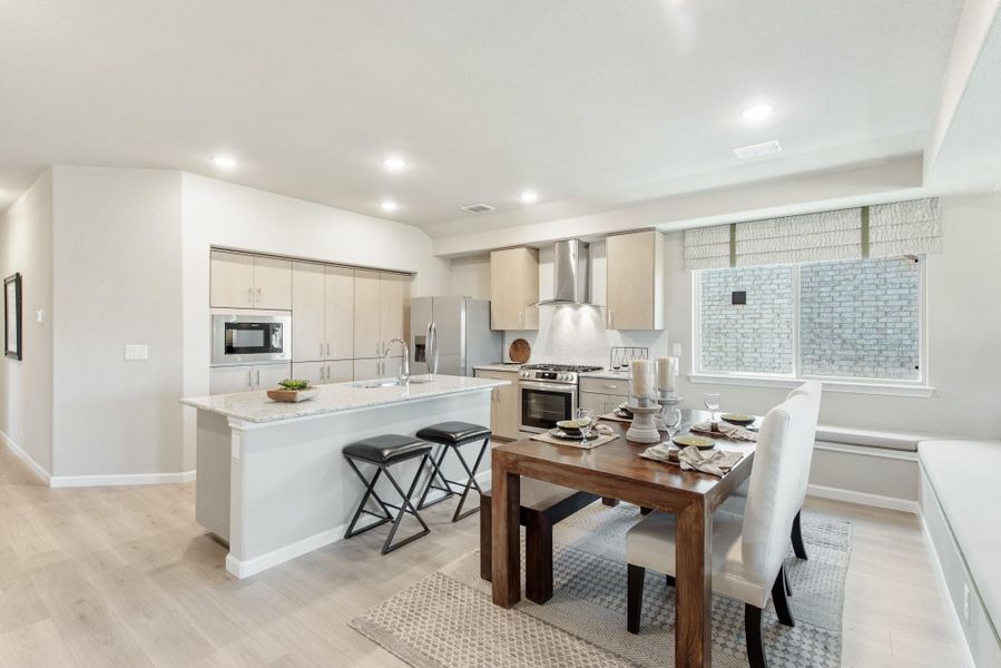 Open-concept kitchen and dining area with light wood cabinets, large island, and stainless steel appliances Open-concept kitchen and dining area with light wood cabinets, large island, and stainless steel appliances