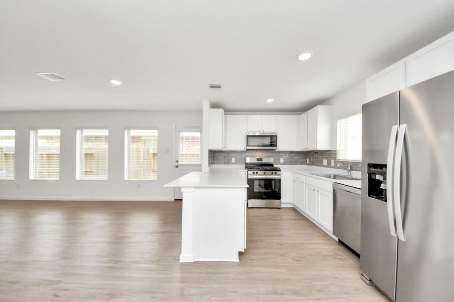Open concept kitchen with abundant cabinet storage.