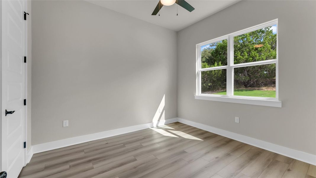 Unfurnished room with a ceiling fan and light wood-style flooring