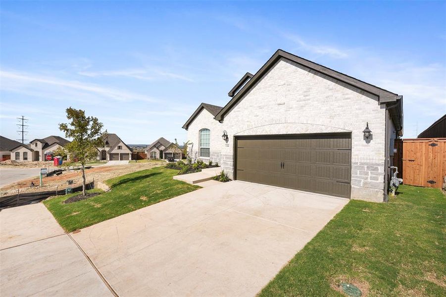 View of front of house featuring a garage and a front yard