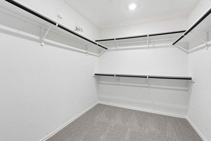 Built-in closet organization system featuring white shelving and black hanging rods Built-in closet organization system featuring white shelving and black hanging rods