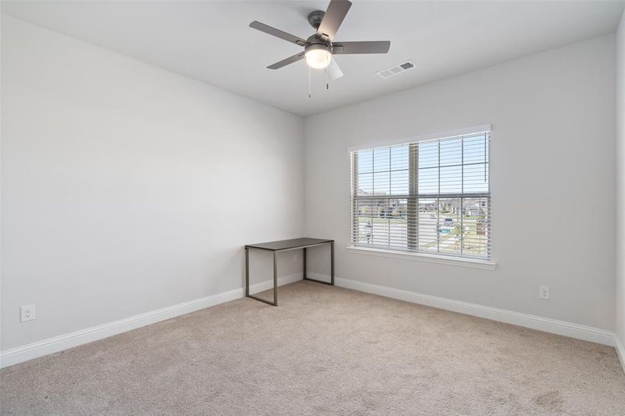 Carpeted empty room featuring ceiling fan