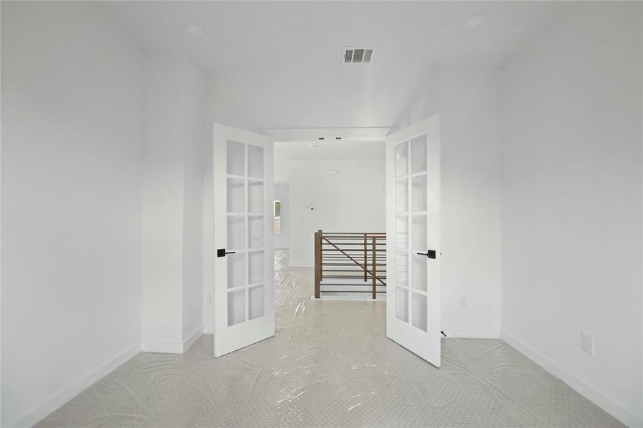 Hallway featuring french doors and an upstairs landing Hallway featuring french doors and an upstairs landing