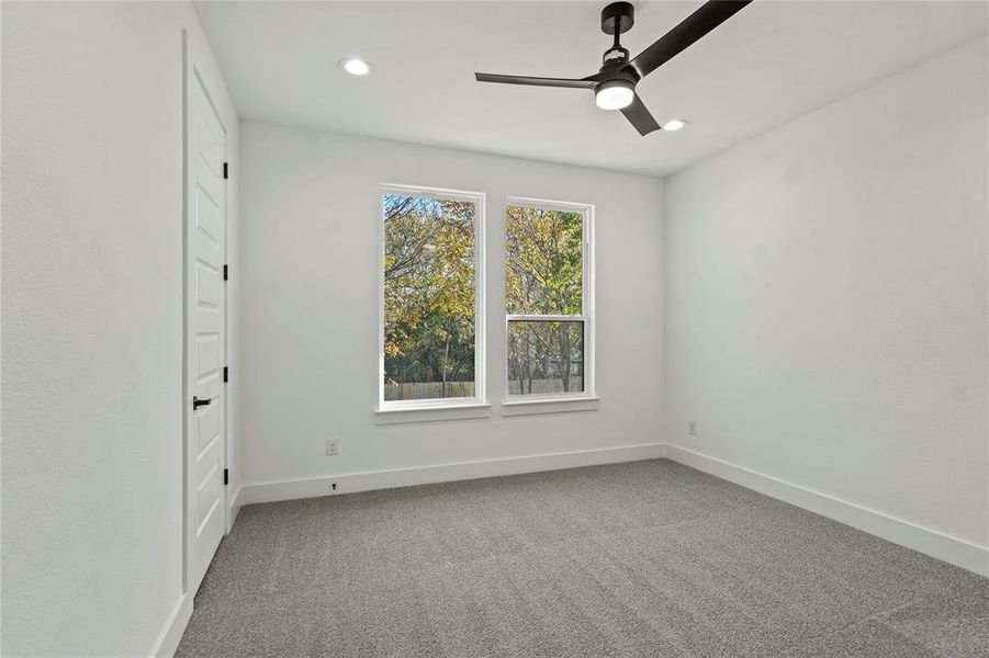 Carpeted empty room with ceiling fan