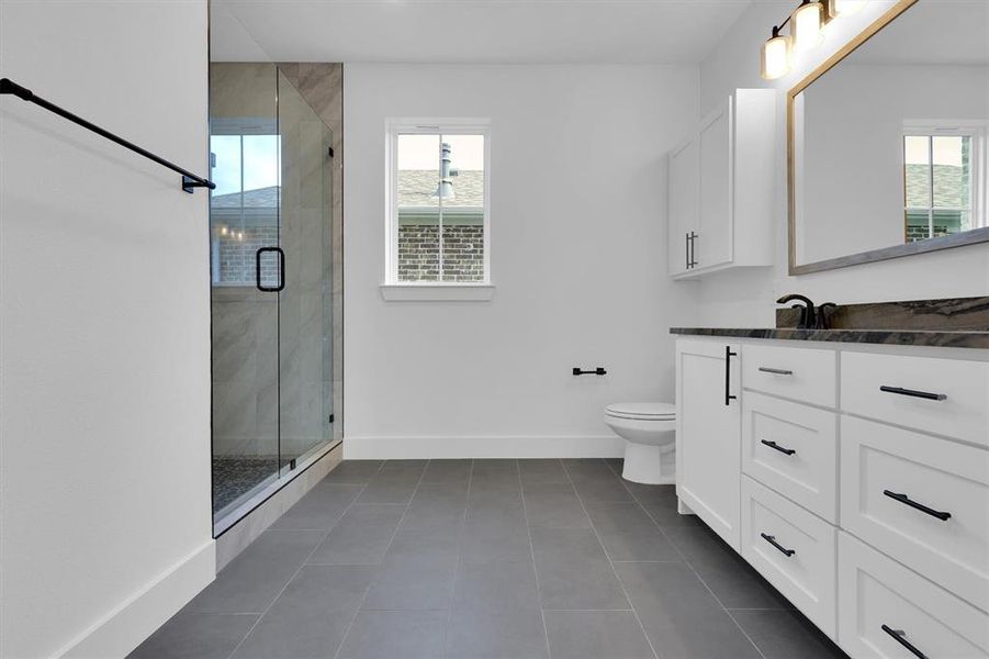 Bathroom featuring vanity, a shower stall, and tile patterned flooring Bathroom featuring vanity, a shower stall, and tile patterned flooring