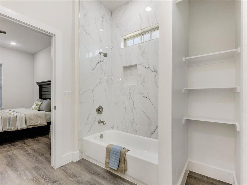 Full bath featuring a combined bath / shower with marble appearance, wood finished floors, ensuite bathroom, and recessed lighting