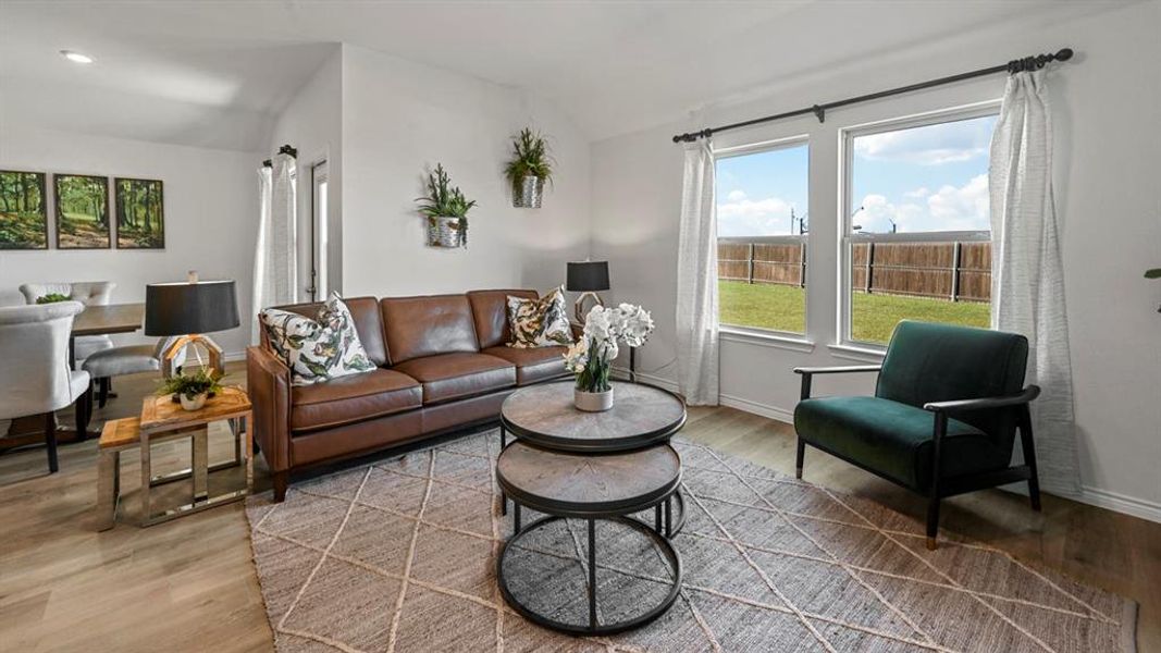 Living room with vaulted ceiling and light wood-style flooring
