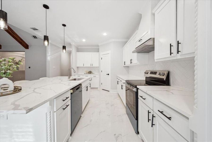 Kitchen with light stone counters, sink, white cabinetry, and appliances with stainless steel finishes