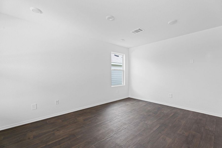 Spare room with baseboards, dark wood-style floors, and visible vents Spare room with baseboards, dark wood-style floors, and visible vents