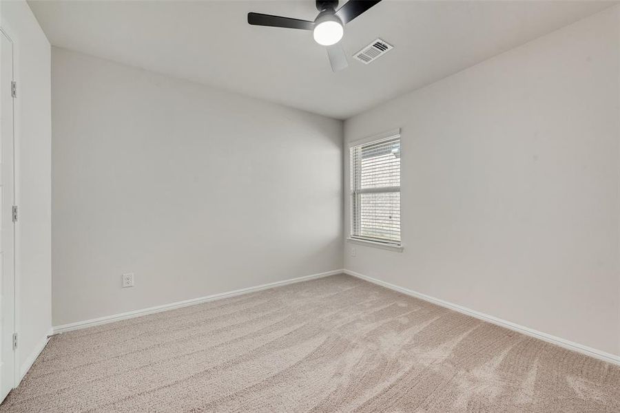 Unfurnished room with light colored carpet and a ceiling fan Unfurnished room with light colored carpet and a ceiling fan