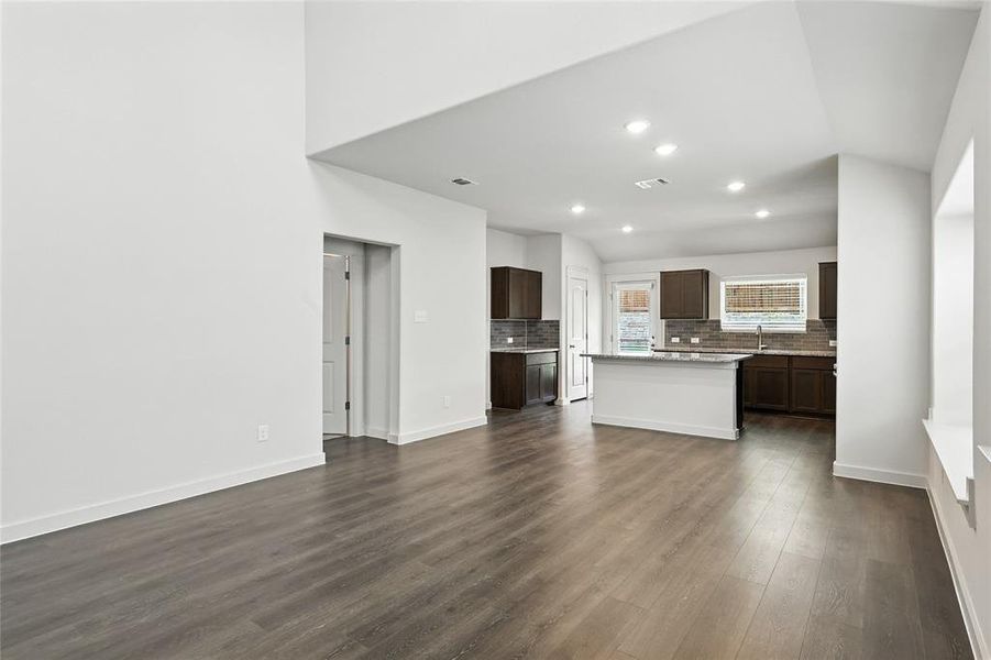 Unfurnished living room featuring dark wood-type flooring and recessed lighting Unfurnished living room featuring dark wood-type flooring and recessed lighting
