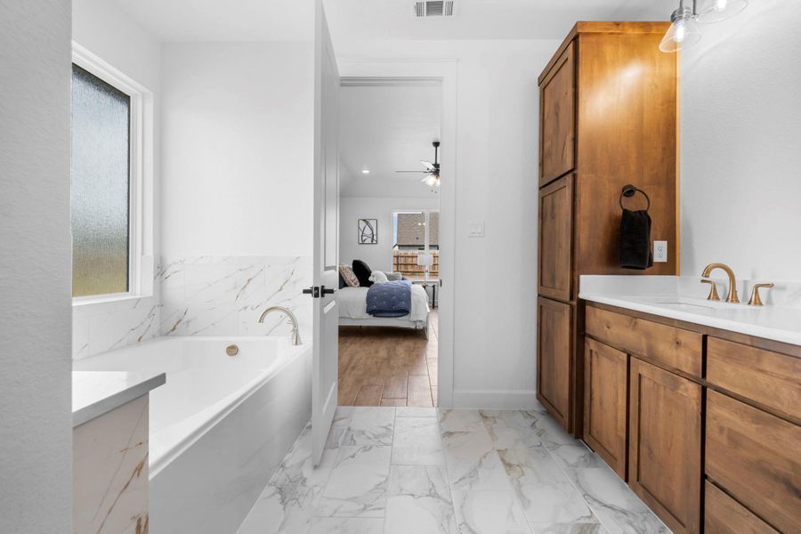 Bathroom featuring vanity, ensuite bathroom, and healthy amount of natural light