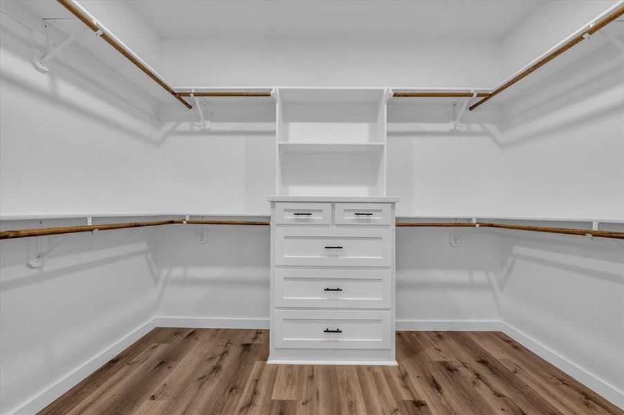 Walk in closet featuring light wood-style flooring Walk in closet featuring light wood-style flooring