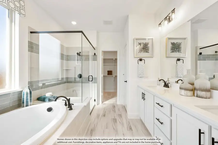 Master bathroom with soaking tub, glass walk-in shower, double vanity, and white cabinets with light wood floors