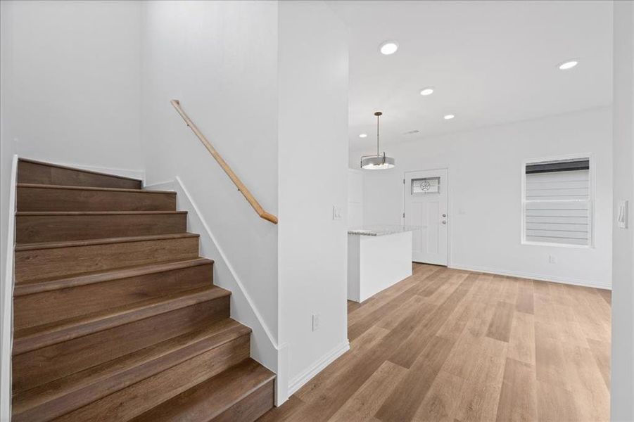 Staircase with wood treads adds character, with easy access to the kitchen and dining area.