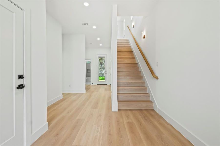 Stairway with recessed lighting and wood finished floors