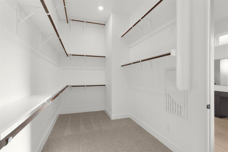 Walk in closet featuring light colored carpet