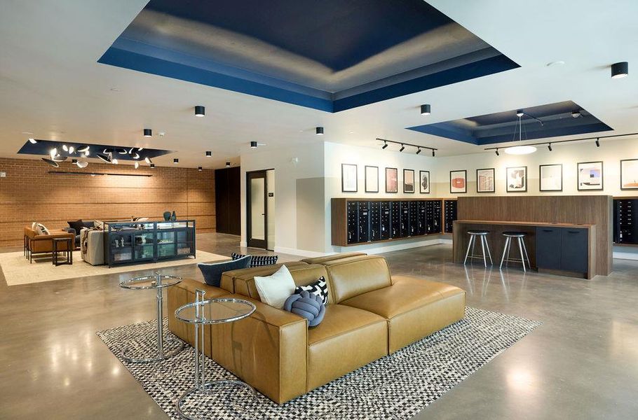 Lobby with a tray ceiling, track lighting, and wood walls