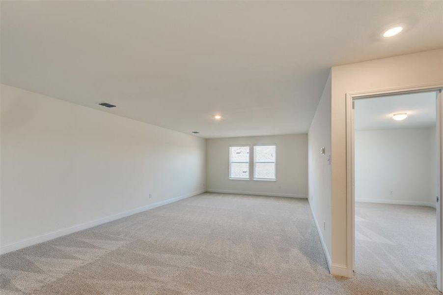 Spare room featuring light colored carpet and recessed lighting