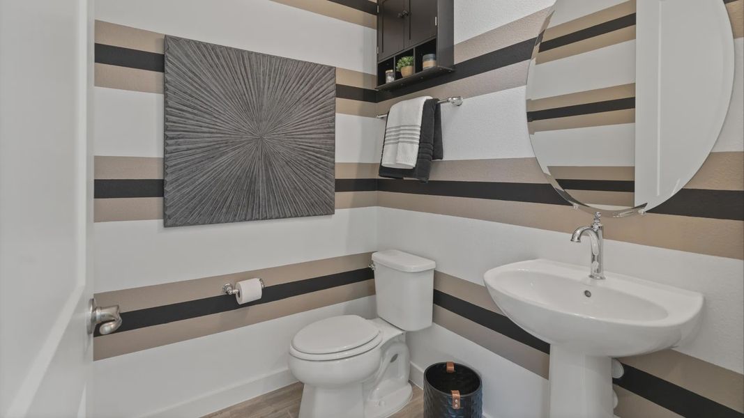 Powder room with pedestal sink in a DRB Home Clementine model at the Trinity Place community.