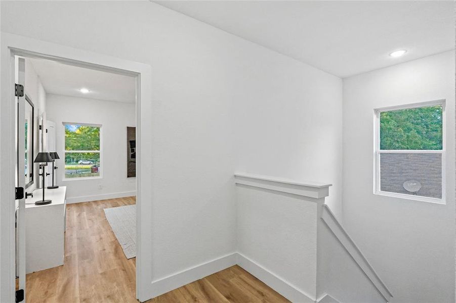 Hallway with light hardwood / wood-style flooring