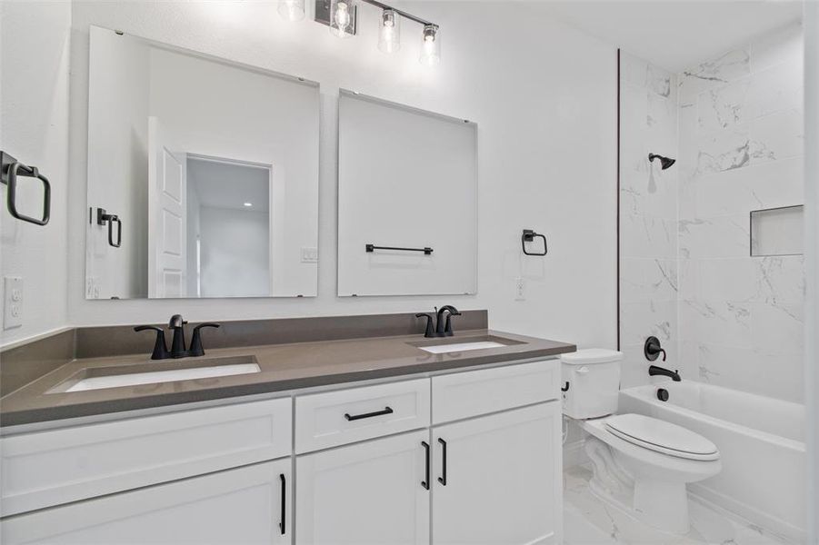 Full bathroom featuring vanity, toilet, and tiled shower / bath combo