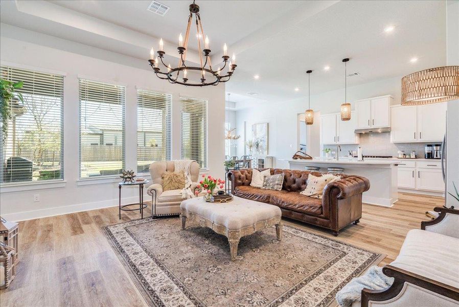 Living room featuring a chandelier and light wood-style flooring Living room featuring a chandelier and light wood-style flooring