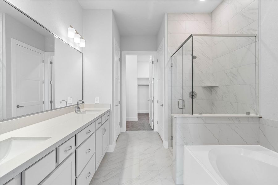Retreat to a private, spa-like primary bathroom designed for relaxation and convenience. A generous double vanity with modern cabinetry offers ample space for two people. The connecting walk-in closet makes getting ready convenient.