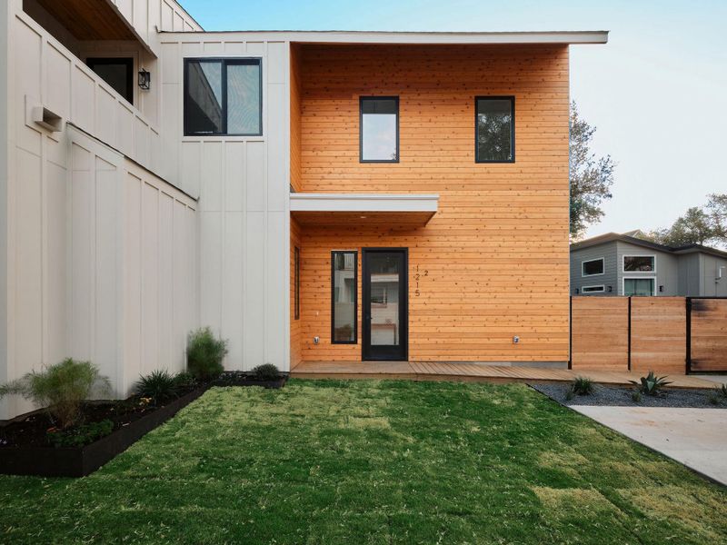 Rear view of property featuring board and batten siding, a deck, and a balcony Rear view of property featuring board and batten siding, a deck, and a balcony