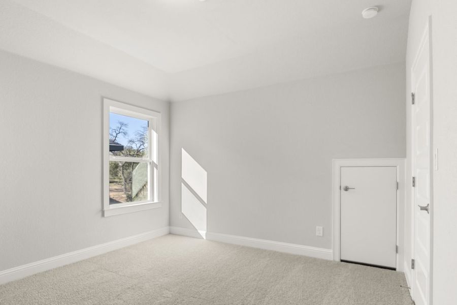 Image of a bedroom with tan carpeting and light grey painted walls with a window and white half door Image of a bedroom with tan carpeting and light grey painted walls with a window and white half door