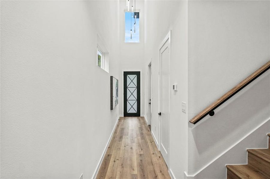 Hallway featuring light hardwood / wood-style floors and a high ceiling