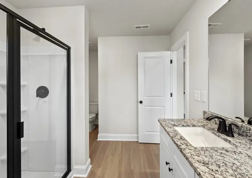 The master bathroom has a glass-enclosed shower
