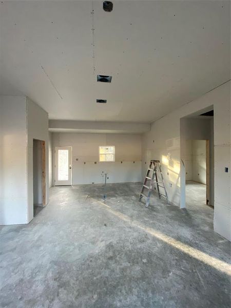 Unfurnished living room featuring concrete floors