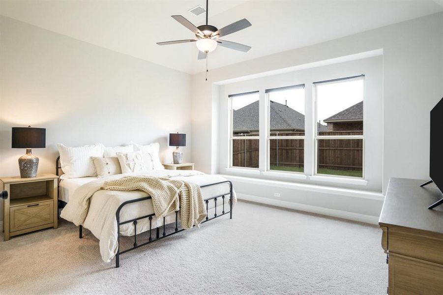 Bedroom featuring light carpet and a ceiling fan Bedroom featuring light carpet and a ceiling fan