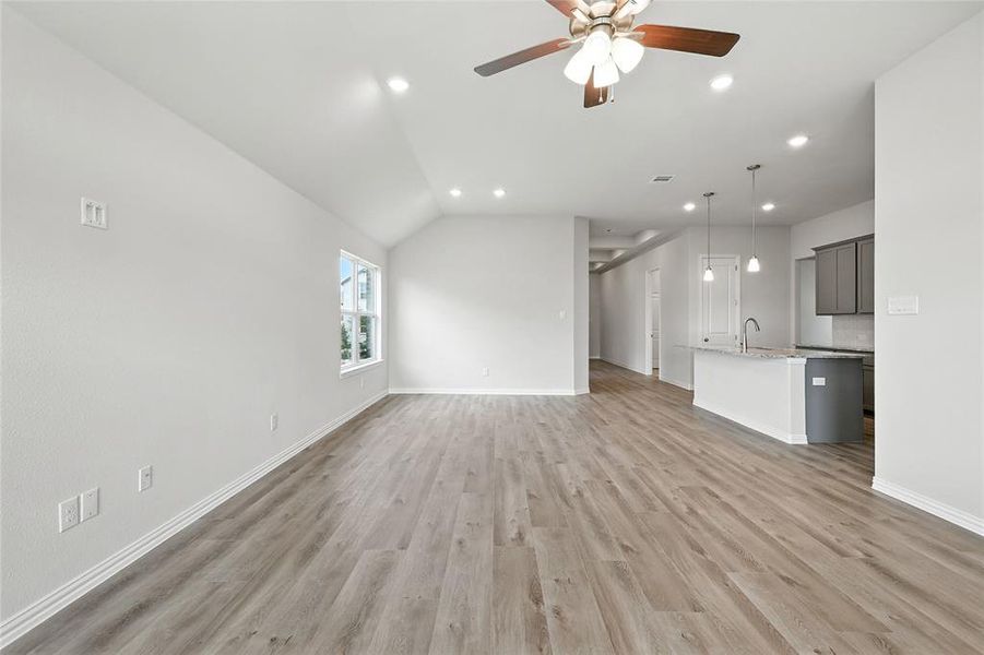 Unfurnished living room with a ceiling fan, recessed lighting, light wood-style flooring, and vaulted ceiling