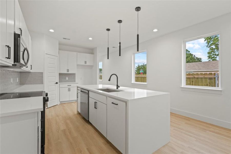 Kitchen with appliances with stainless steel finishes, a sink, plenty of natural light, decorative backsplash, and recessed lighting Kitchen with appliances with stainless steel finishes, a sink, plenty of natural light, decorative backsplash, and recessed lighting