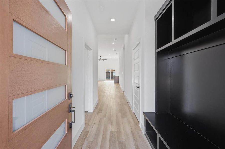 Corridor with light wood-type flooring and recessed lighting