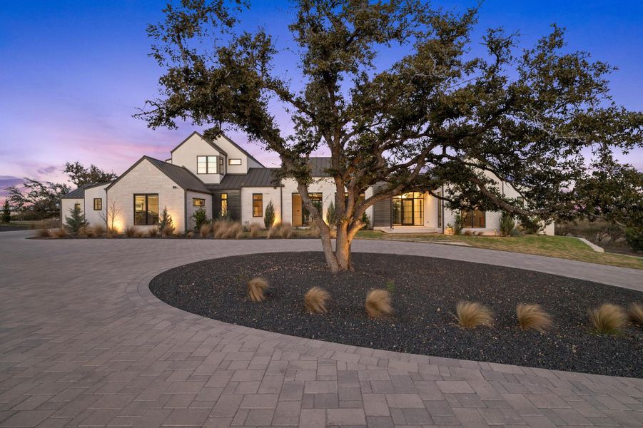 Modern inspired farmhouse featuring metal roof, a standing seam roof, and curved driveway Modern inspired farmhouse featuring metal roof, a standing seam roof, and curved driveway