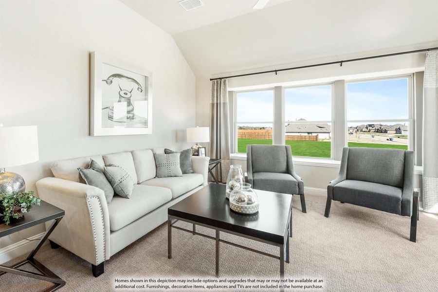 Living room with vaulted ceiling, light sofa, gray accent chairs, and large windows overlooking a backyard.