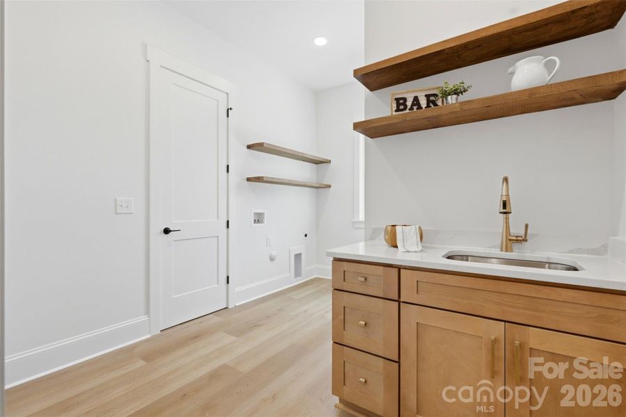 the laundry room mudroom! complete w/ wood shelving & a sink