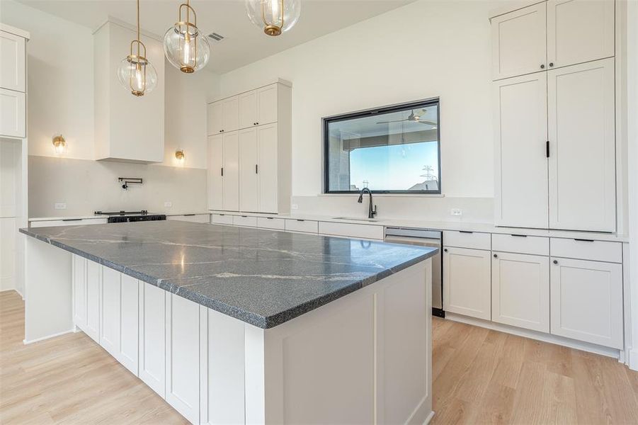 Kitchen with white cabinets and light hardwood / wood-style floors