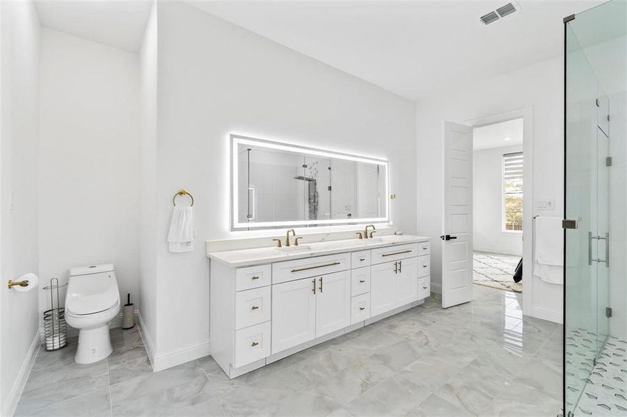 Full bathroom with double vanity, a shower stall, and light marble finish flooring