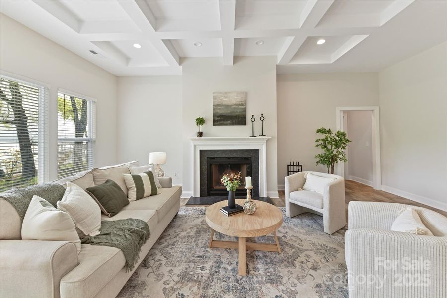 Great Room features wood burning fireplace, coffered ceiling, LVP floors & gorgeous lake views!