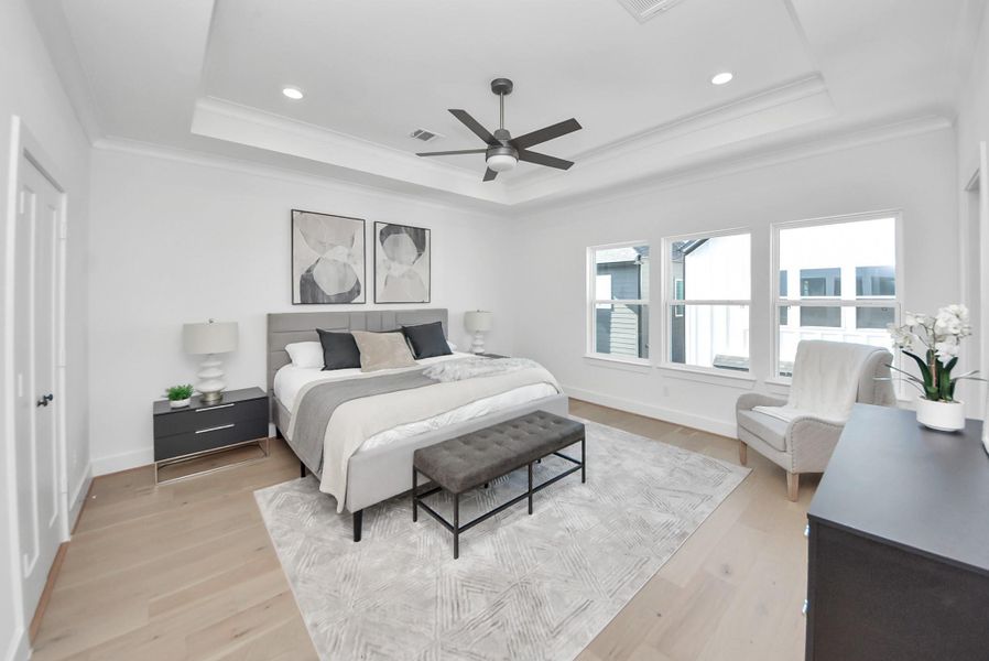 This spacious bedroom offers a serene retreat with a modern design, a large bed, and stylish furnishings. Natural light streams through multiple windows, highlighting the cozy seating area, ceiling fan, and light wood flooring for a bright, relaxing atmosphere. This spacious bedroom offers a serene retreat with a modern design, a large bed, and stylish furnishings. Natural light streams through multiple windows, highlighting the cozy seating area, ceiling fan, and light wood flooring for a bright, relaxing atmosphere.