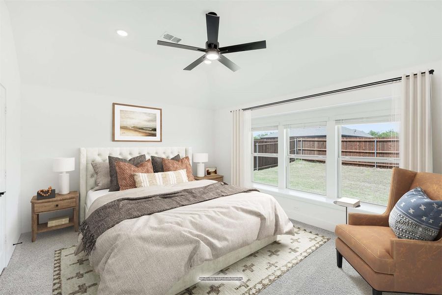 Bedroom with tufted upholstered bed, ceiling fan, large windows, and sitting chair on carpet Bedroom with tufted upholstered bed, ceiling fan, large windows, and sitting chair on carpet